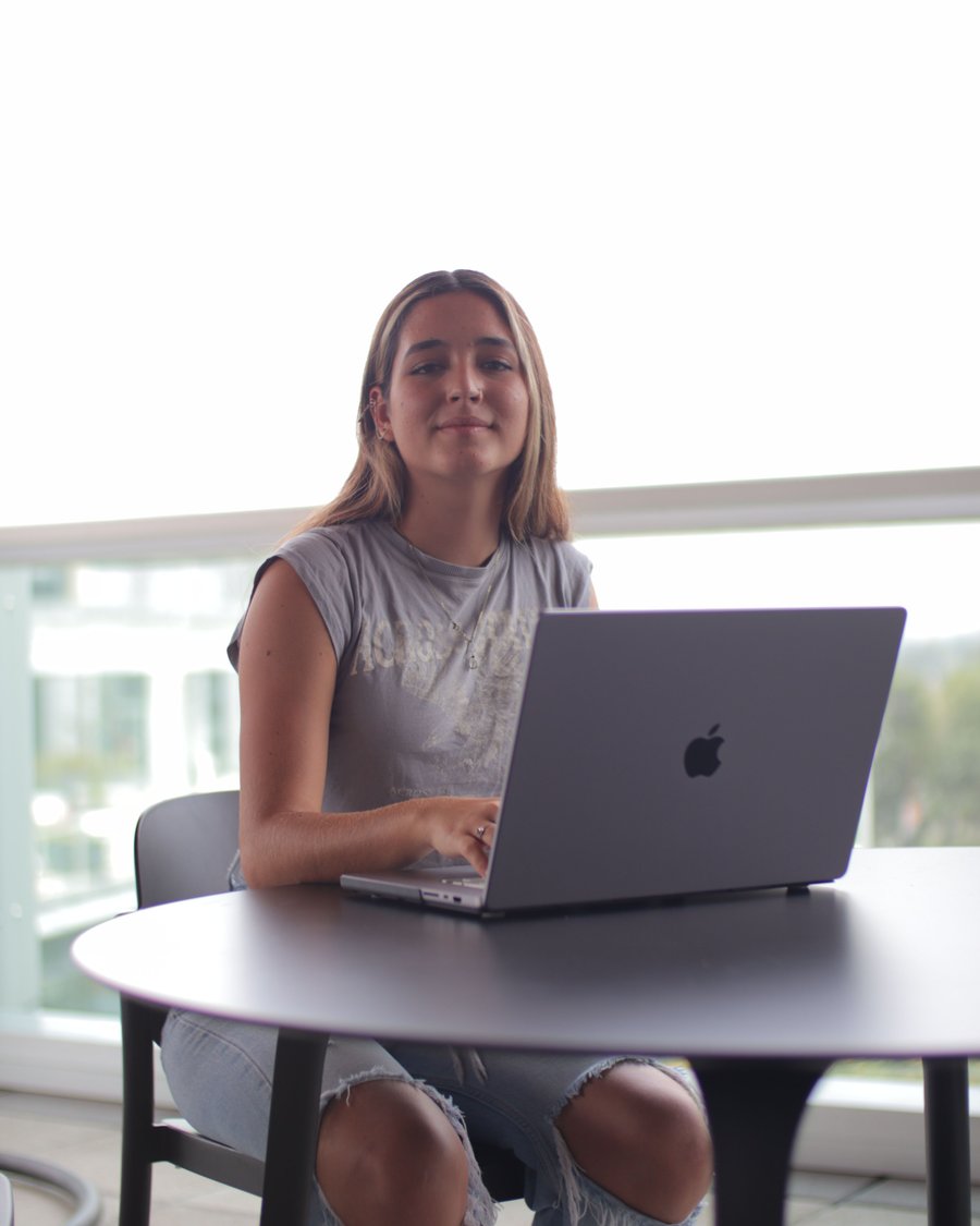 aluna à mesa com o notebook aberto, estudando com constância